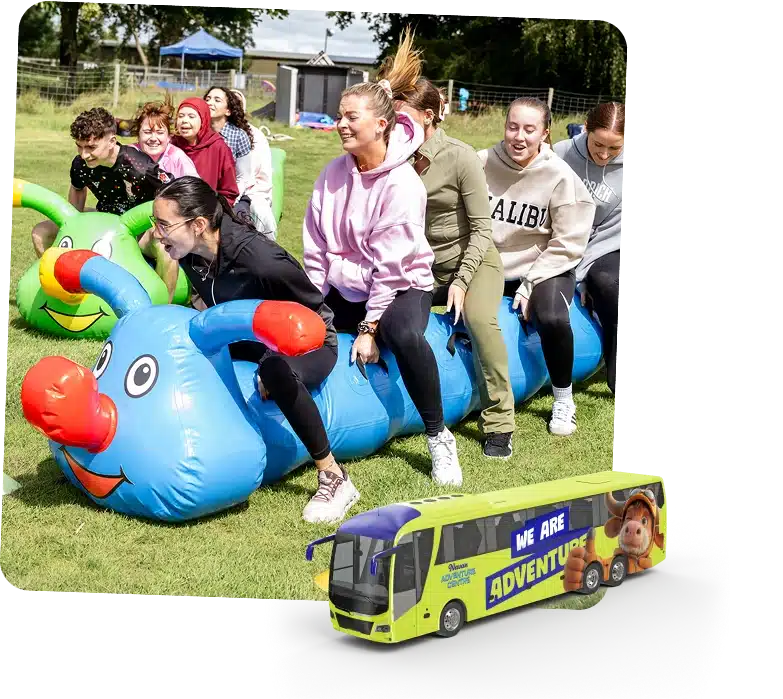 A group of young women laugh as they ride a large inflatable caterpillar outdoors on grass at the Navan Easter event. In the foreground is a graphic of a yellow bus with "We Are Adventure" written on the side.