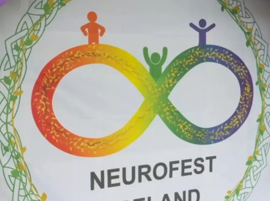 A Neurofest Ireland banner features a rainbow infinity symbol with three simplified human figures on top, surrounded by colourful balloons. The text "NEUROFEST IRELAND" appears below the symbol.